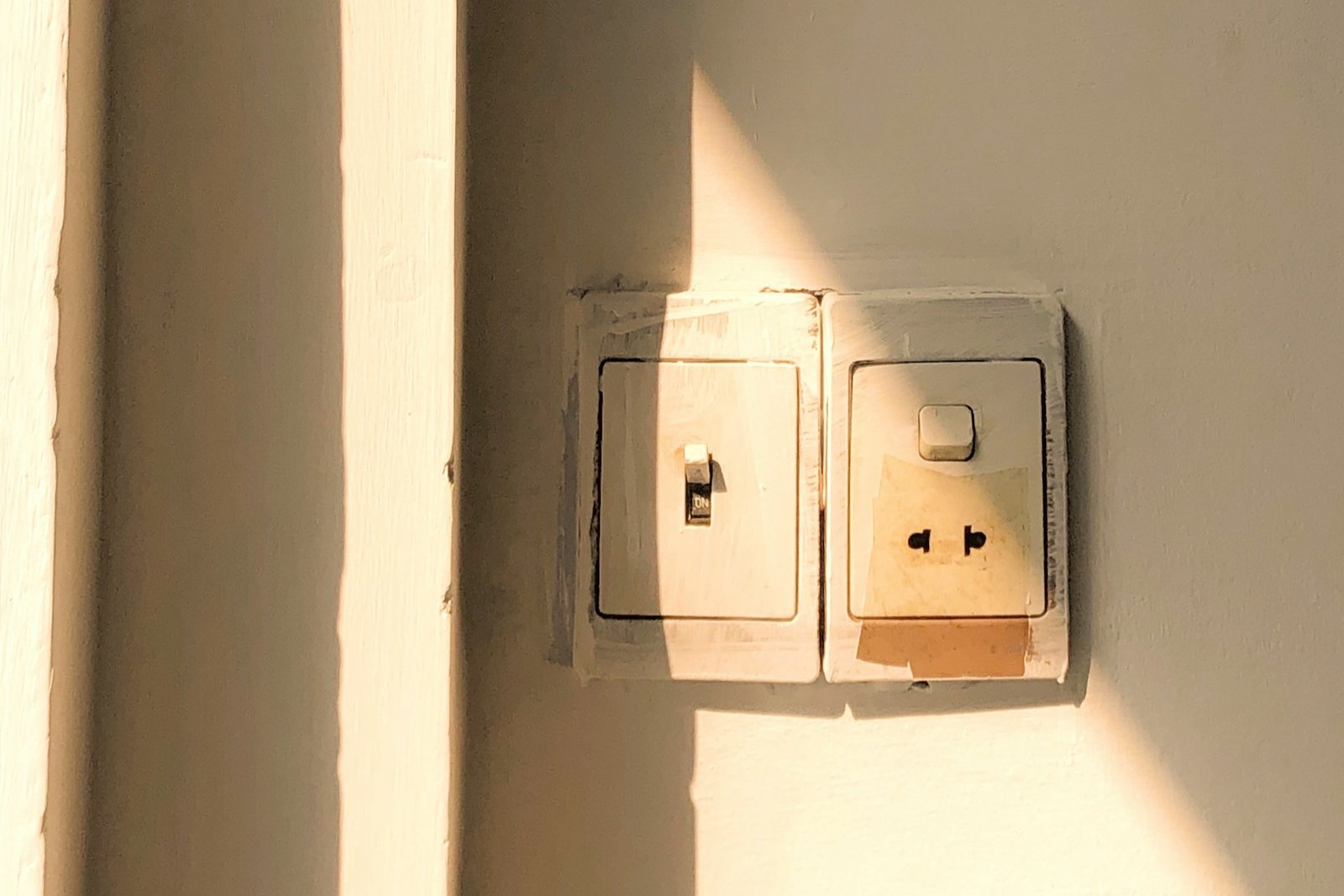 Geöffneter Lichtschalter mit sichtbarem Einsatz in einer Wand