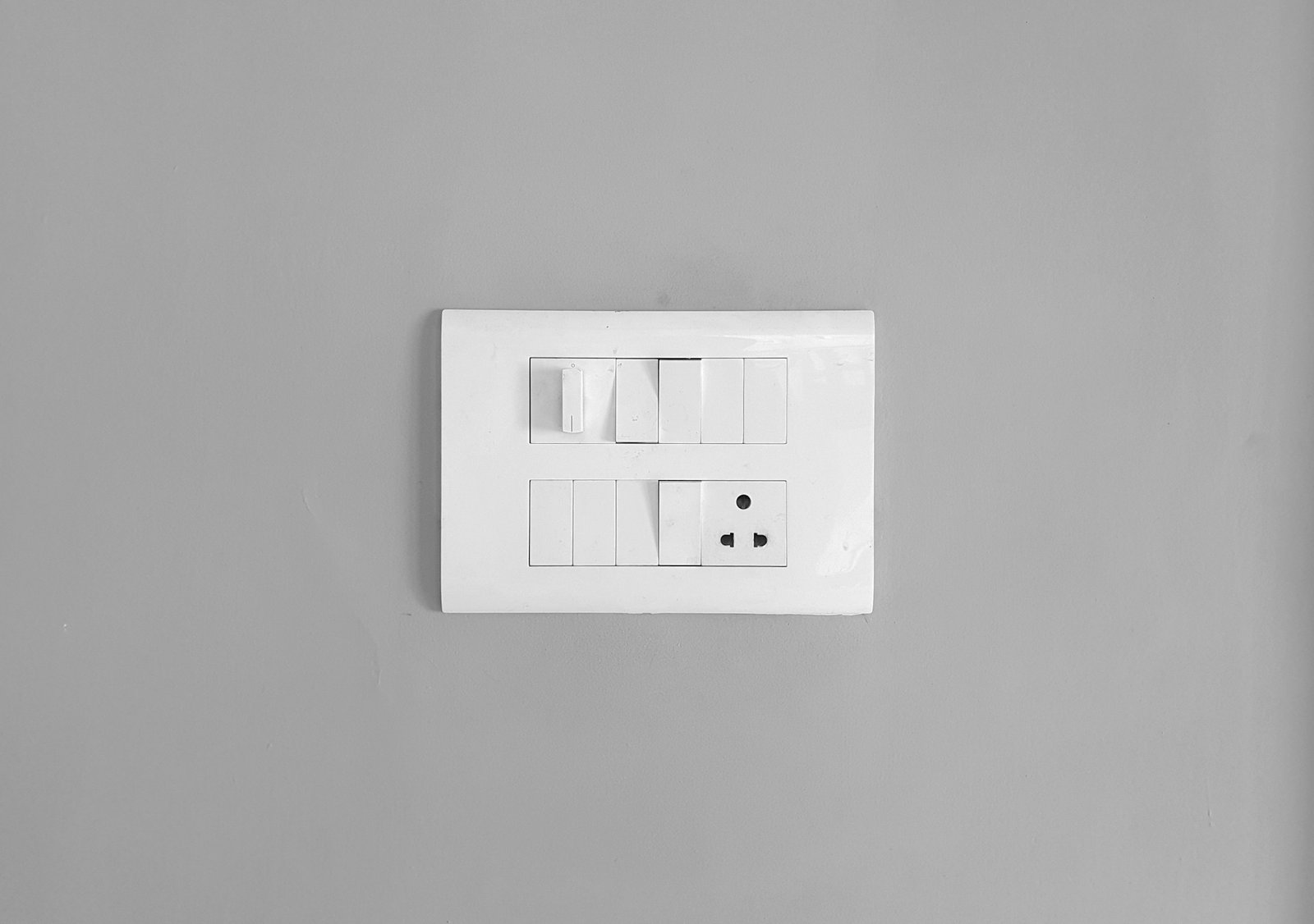 Nahaufnahme eines Lichtschalters an einer weißen Wand