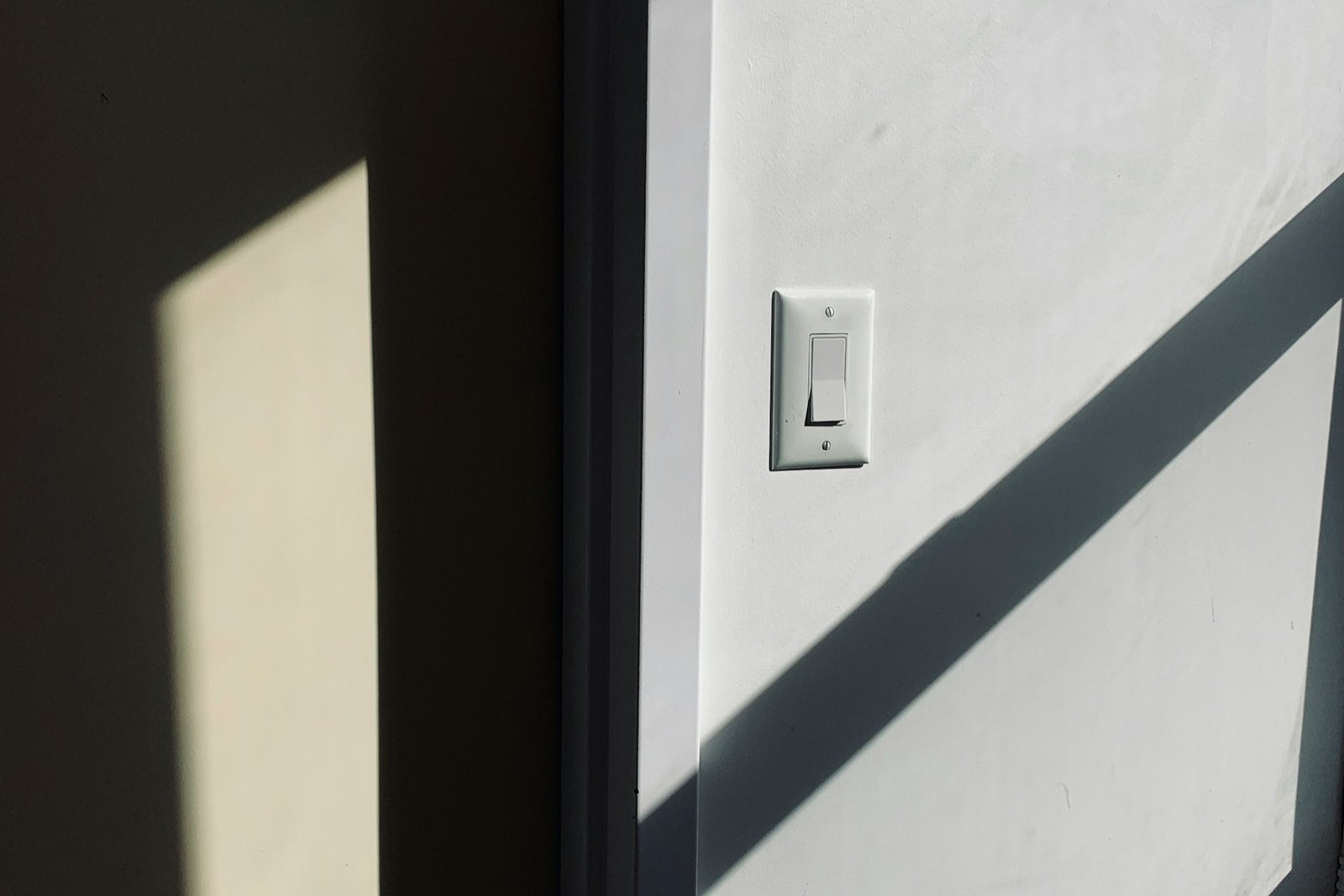 Lichtschalter an einer hellen Innenwand in einer Wohnung